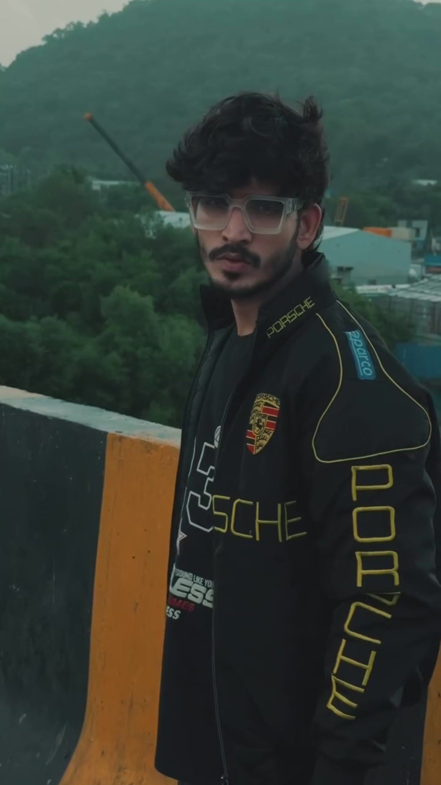 a man wearing porsche racing jacket parachute material by modyourself, which is an F-1 Edition Jacket